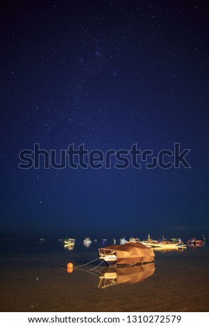 the atmosphere at night on the beach of Sanur, Bali, Indonesia. if the sky is clear we can see the Milky Way galaxy in the Balinese sky. boats that are moored around the beach become beautiful objects