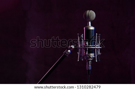 Close up studio condenser microphone with  anti-vibration mount live recording neon blue and pink color lights background