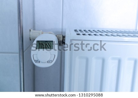 German lettering "heiss" means hot on digital display of an radiator thermostat in the bathroom