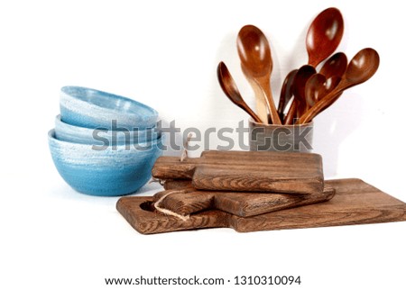 Kitchen and kitchenware. Rustic and rough crockery and utensil.  Wooden blue bowls, spoons, coffee mug and cutting boards. Country style. Wooden handmade tableware. White background