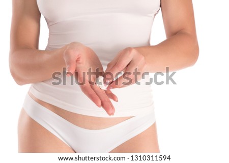 Woman cleaning her hands by white wet wipe, female well groomed fingers with French manicure, cropped fit body in white top and panties. Close up, isolated on a white. Beauty, skin and body care