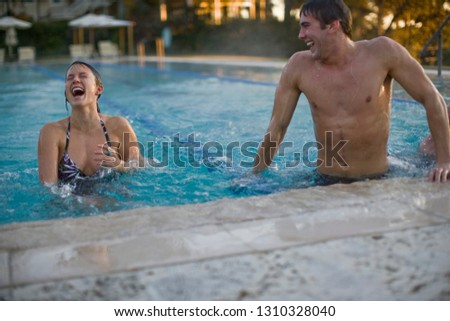 Young couple laughing in swimming pool