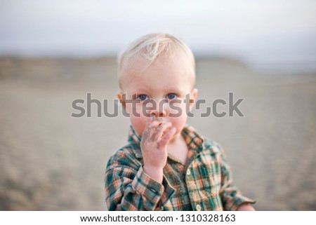 Little boy eating sand on the beach