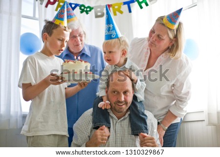 Family crowding around a birthday cake