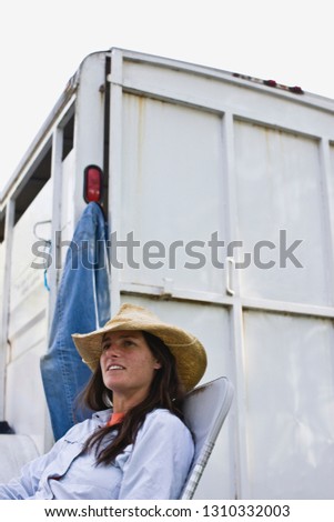 Mid-adult woman sitting beside a horse float.