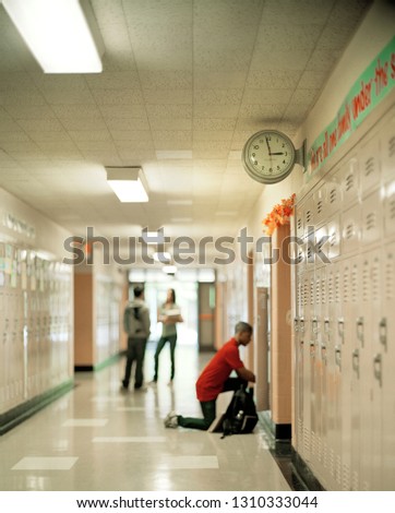 Boy getting something out of his locker at school.