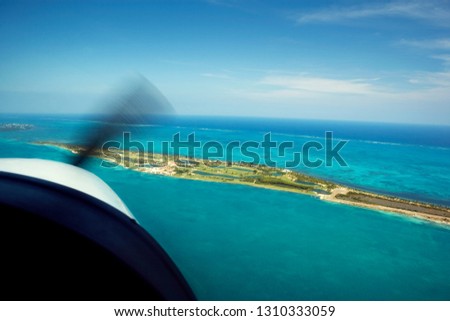 Plane flying over a tropical island.