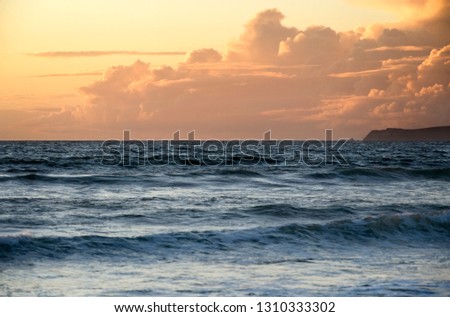 Seascape under a sky at sunset.