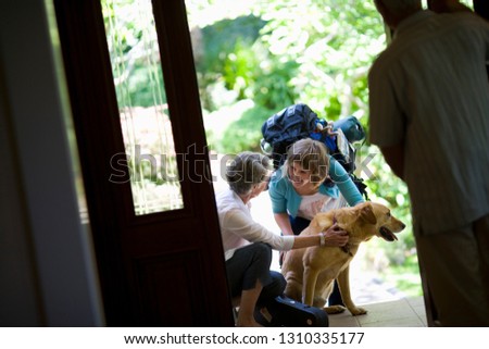 Parents and the family dog greeting their daughter who has been travelling