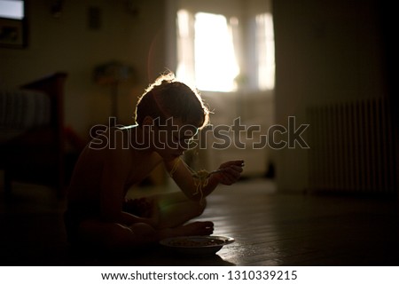 Boy eating spaghetti on the floor