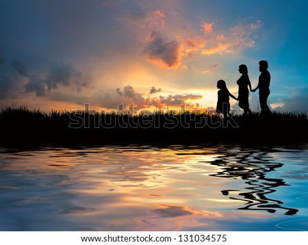 Happy family walking on the beach on a background of the majestic sunset