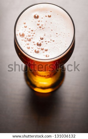 glass of fresh lager beer on black table Royalty-Free Stock Photo #131036132