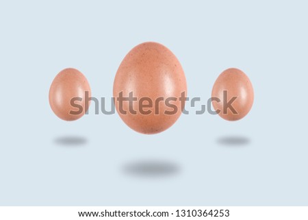 three Levitating eggs on a light background, conceptual Easter postcard