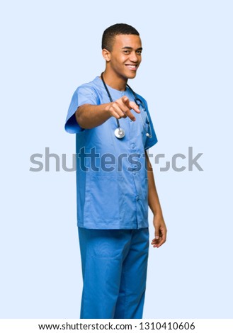 Surgeon doctor man points finger at you with a confident expression on isolated background