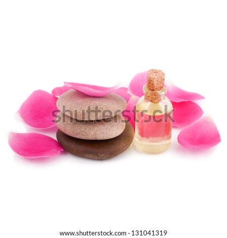 Spa stones with rose petals and essential oil isolated on white background