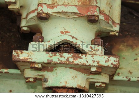 Detail of old machinery with faded paint and rust.