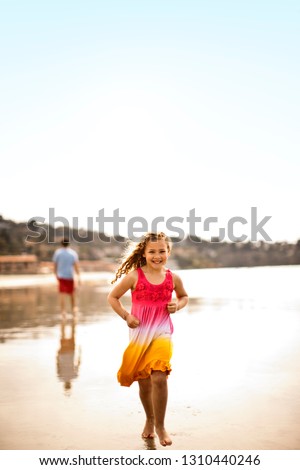 Young girl running along the beach.