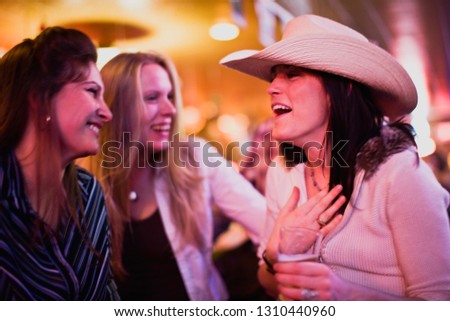 Young woman laughing with friends in a bar