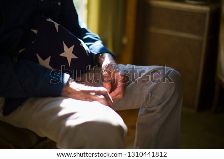 Senior man with a folded American flag