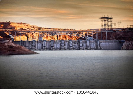 Large industrial dam stretching across a river in an arid landscape.
