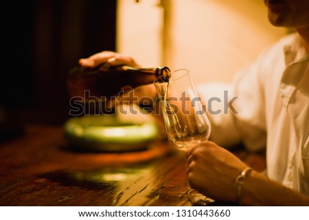 Beer being poured into a glass by a man.