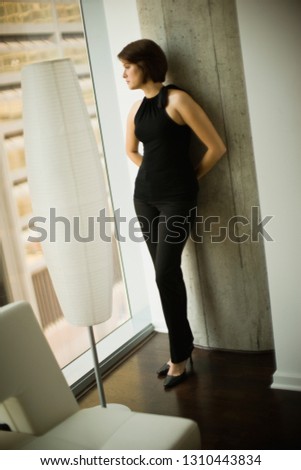Young businesswoman looking out the window of an office.