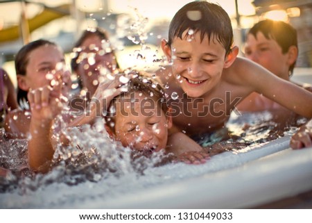 Group of children having fun playing together in a hot tub.