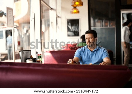 Thoughtful mid adult man enjoying a cup of coffee at a diner.