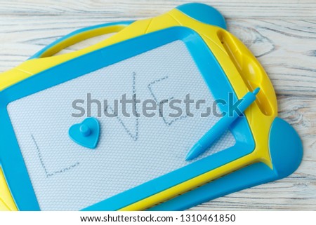 blue children's magnetic drawing board with pen .background for a toy store Learning to draw. children's inscription I love you.child developing game with space for text