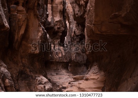 abstract soft focus yellow red and brown cave and steep rocks wall narrow path way