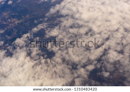 Stratosphere, view of the earth through clouds. Seascape, top view, from the airplane window.