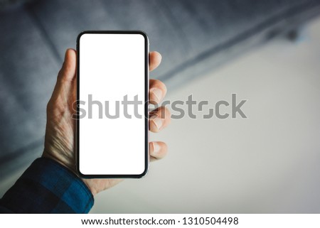 Mockup image man hand holding texting using black mobile,cell phone at desk with copy space,white blank screen for text.concept for contact business,people communication,technology electronic device. 