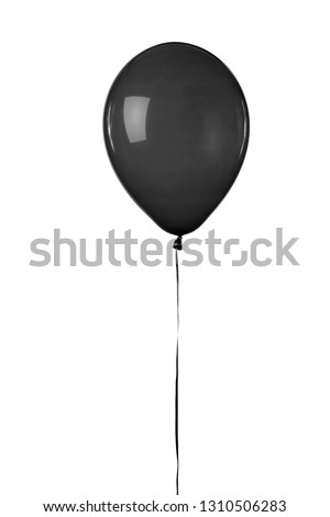 A black toy balloon inflated with helium, floating in front of a white background.