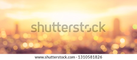 Summer sun blur golden hour hot sunset sky with city rooftop view background cityscape office building landscape blurry urban warm bright heat wave lights skyline heatwave bokeh for evening party  Royalty-Free Stock Photo #1310581826