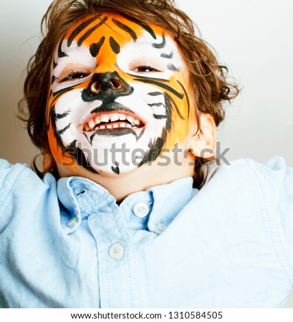 little cute boy with faceart on birthday party close up, tiger