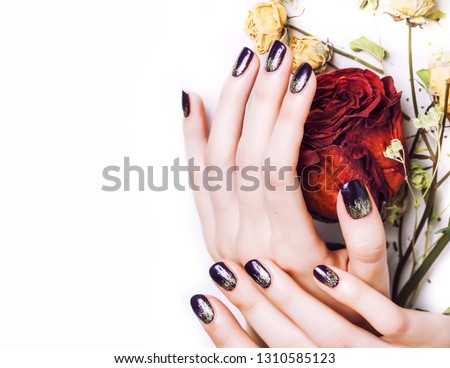 close up picture of manicure nails with dry flower red rose