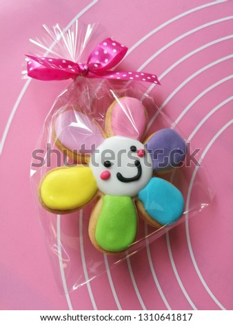 Closeup of fancy sugar cookie, colorful flower cookie,  in plastic bag.