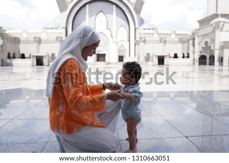 A young muslim woman and her son visiting a mosque
