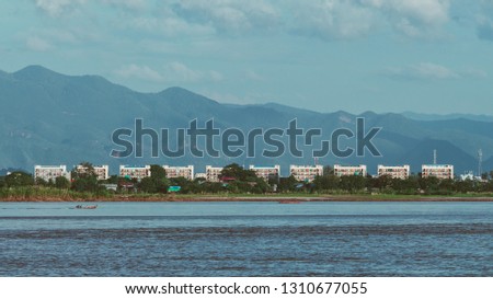 Building on the river and mountains in background