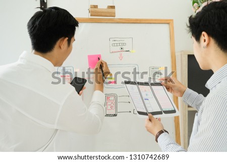 Two colleagues website development sketching UX UI wireframe layout design for application on mobile.