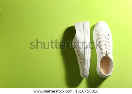 Pair of stylish sneakers on color background, top view with space for text