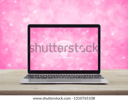 Heart love wifi flat icon modern laptop computer with love heart screen on wooden table over pink background, Internet online love connection, Valentines day concept