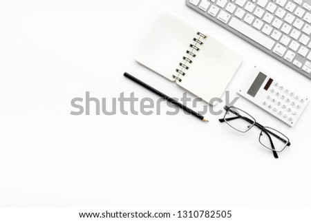 Office desk in order. Geometry. Computer keyboard and office supplies, glasses on white background top view copy space
