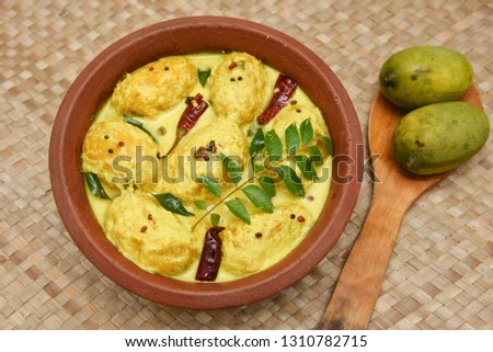 Traditional yellow mango curry or Mampazha Pulissery sweet and sour dish Kerala India . Made from organic raw green mango, coconut milk, seasoned with curry leaves, mustard, Indian red Kashmir chilli.