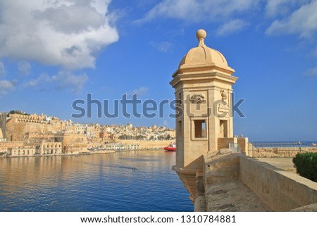 The photo was taken in the public park of the city of Senglea on the island of Malta. The picture shows the famous tower with images of the ear and eyes against the background of the city of Valletta.