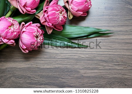 Beautiful pink lotus flower for praying buddha on wooden background.