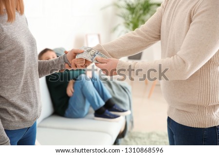 Man giving alimony to his ex-wife at home Royalty-Free Stock Photo #1310868596