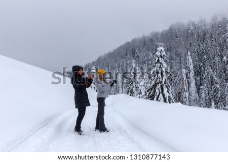 Tourists walking a snowy trail in the mountains