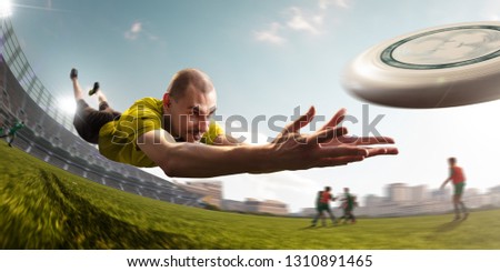 plyear play ultimate flying disc in stadium. Around beautiful sunny day