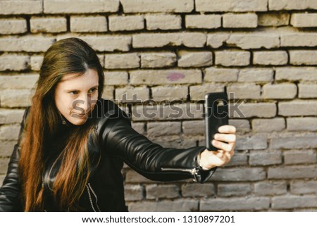 Young woman taking a photo of herself to show her beauty on social networks.